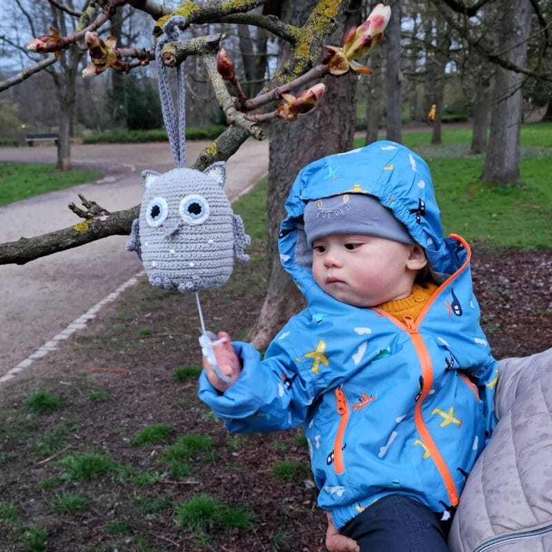 12361-Spieluhr-Eule-LUNA-in-Grau-mit-Baby-in-der-Natur-zu-Fruehlingsbeginn Gehäkelte Spieluhr Eule LUNA in Grau - hängend im Kinderbett
