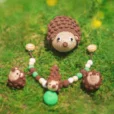 Hedgehog HARRY rattle ring arranged with other Hedgehog HARRY products on grass