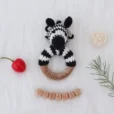 Zebra STRIPEY rattle ring arranged on a decorative background with wooden and natural elements