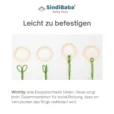 Schlaufe der Kinderwagenkette wird in einen hellbeigen Befestigungsring eingefädelt.
