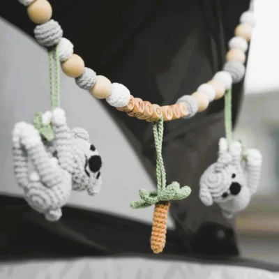 Personalisierte Kinderwagenkette mit Koala-Motiv und Namen Antonia am Kinderwagen befestigt.